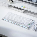 GravaStar White keyboard on a desk with a monitor and small decorative items in the background